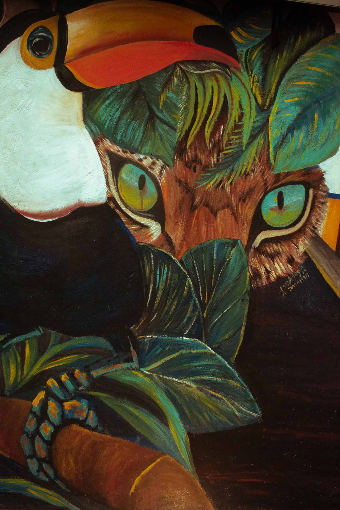 Mural de tucán y jaguar entre hojas
